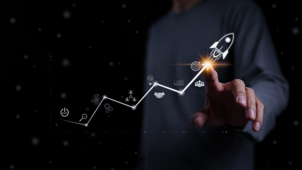 startup business and investment concept. businessman is touching the growing business graph. planning and starting corporate business start up, rocket icon soars with speed to hit the growth target.