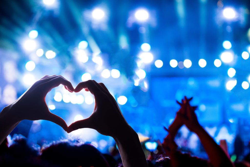 crowd of audience at during a concert with silhouette of a heart